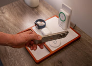 A smartphone magnetically connected to a MagSafe wireless charger on a desk.