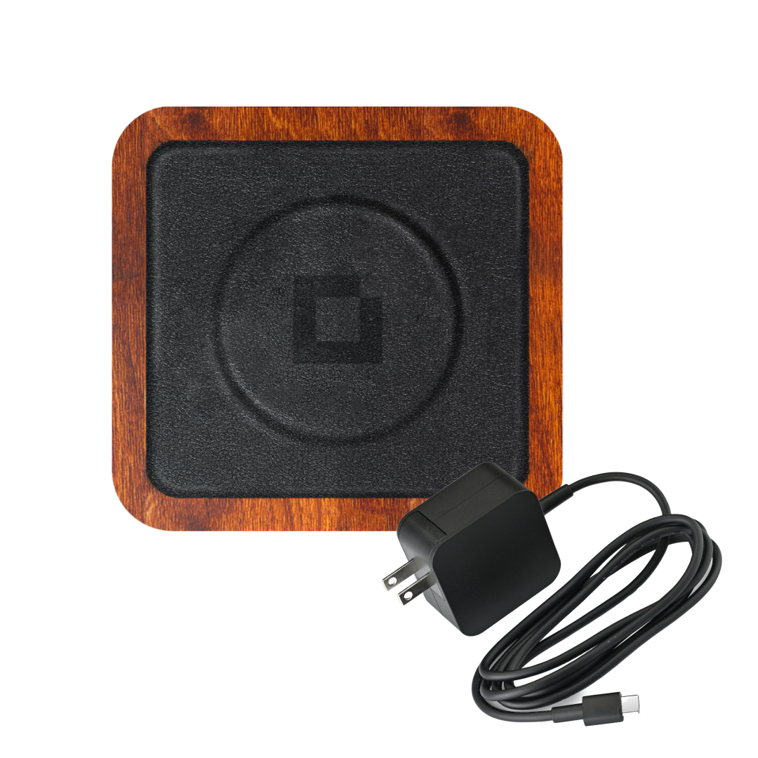 The UNO Black is a single-coil, MagSafe-compatible Qi wireless charging pad featuring an oak wooden border and black center, and comes with a black wall charger and USB-C cable.