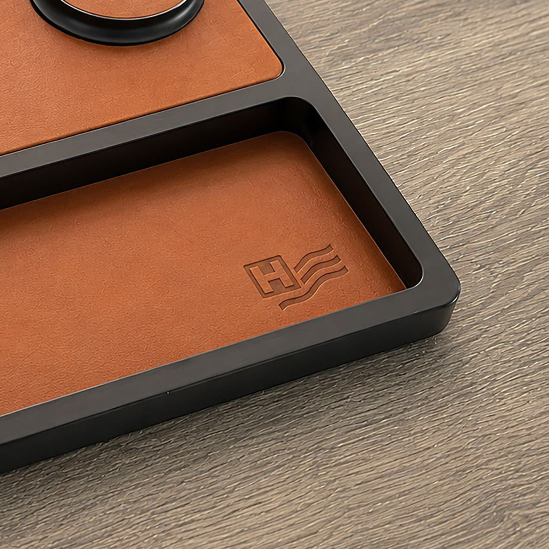 Close-up of a client logo laser-engraved into full-grain saddle leather