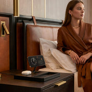 Qi2 wireless charging station with iPhone on wooden nightstand