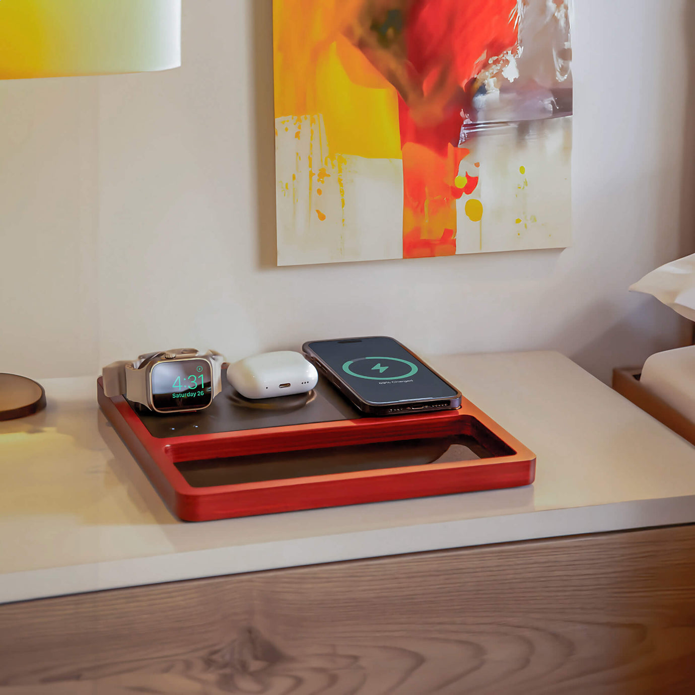 A nightstand charging organizer keeps multiple devices powered and tidy beside a lamp.