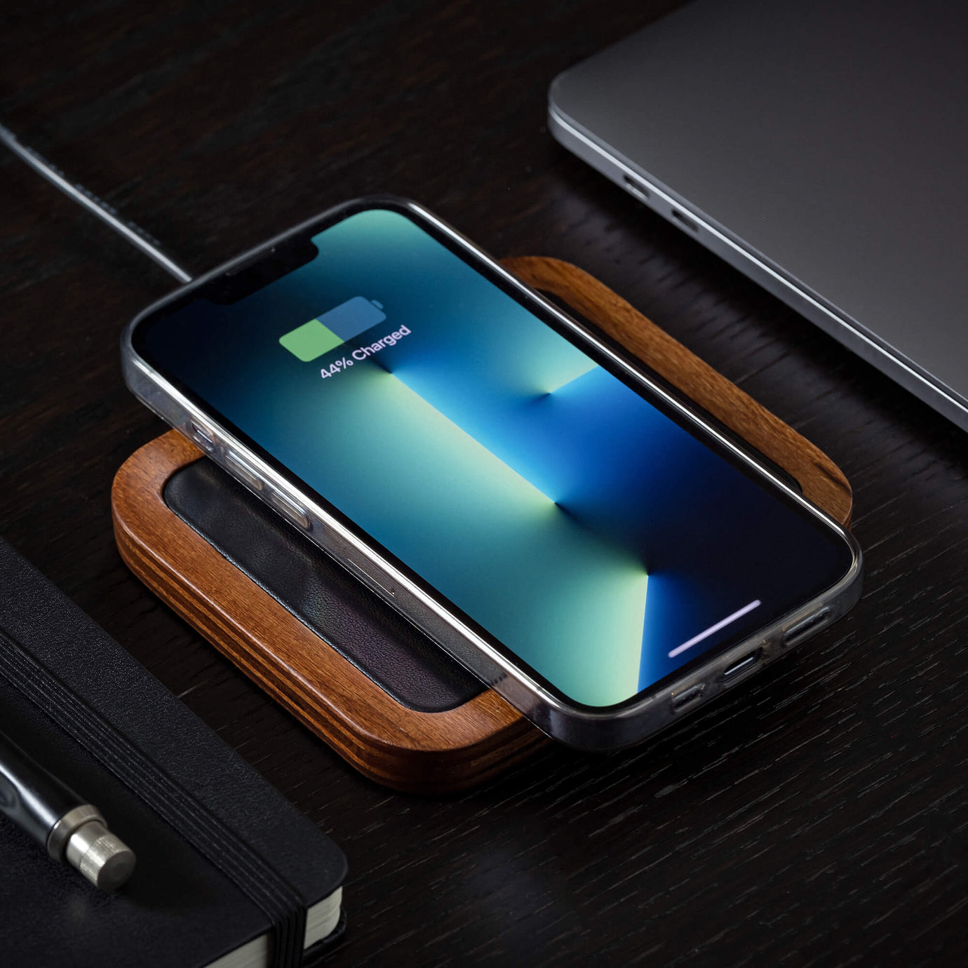 A single device MagSafe charger wirelessly charging an iPhone on a minimalist nightstand.