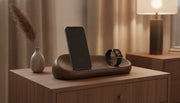 Premium wooden charging station on walnut nightstand with iPhone and Apple Watch, warm ambient lighting, quiet luxury aesthetic
