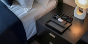 A multi-device charging station and dock powering a smartphone and smartwatch on a nightstand.