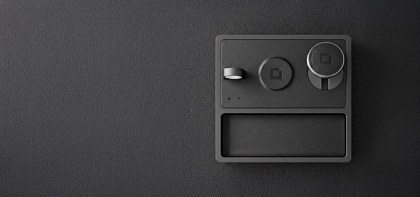 MagSafe charging pad for two devices on a desk next to an iPhone.