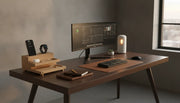 Premium home office desk with a wood wireless charging station featuring an iPhone, Apple Watch, and AirPods on a clean modern desk