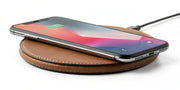 A premium leather wireless charger with a smartphone, showing the quality that determines its price.