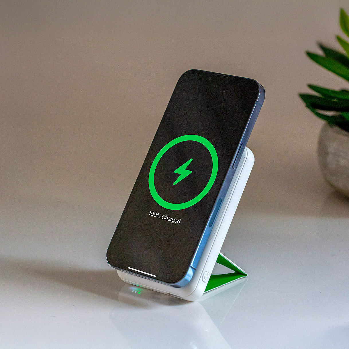 Apple wireless power bank charging an iPhone, Apple Watch, and AirPods.