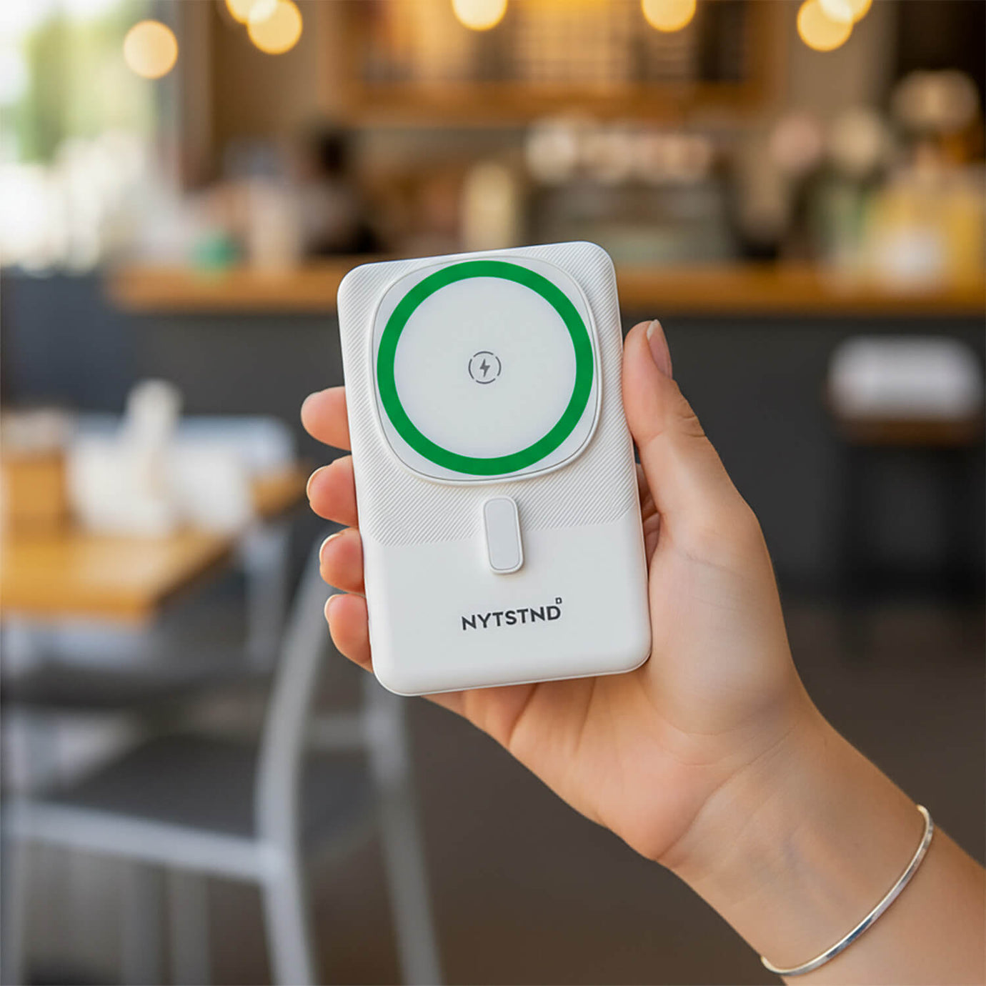 A MagSafe compatible wireless power bank magnetically charging an iPhone.