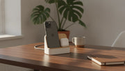 Premium wooden charging station with iPhone and AirPods on a walnut desk with warm natural light