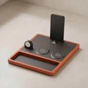 A luxury walnut wood MagSafe charger on a desk next to an iPhone.