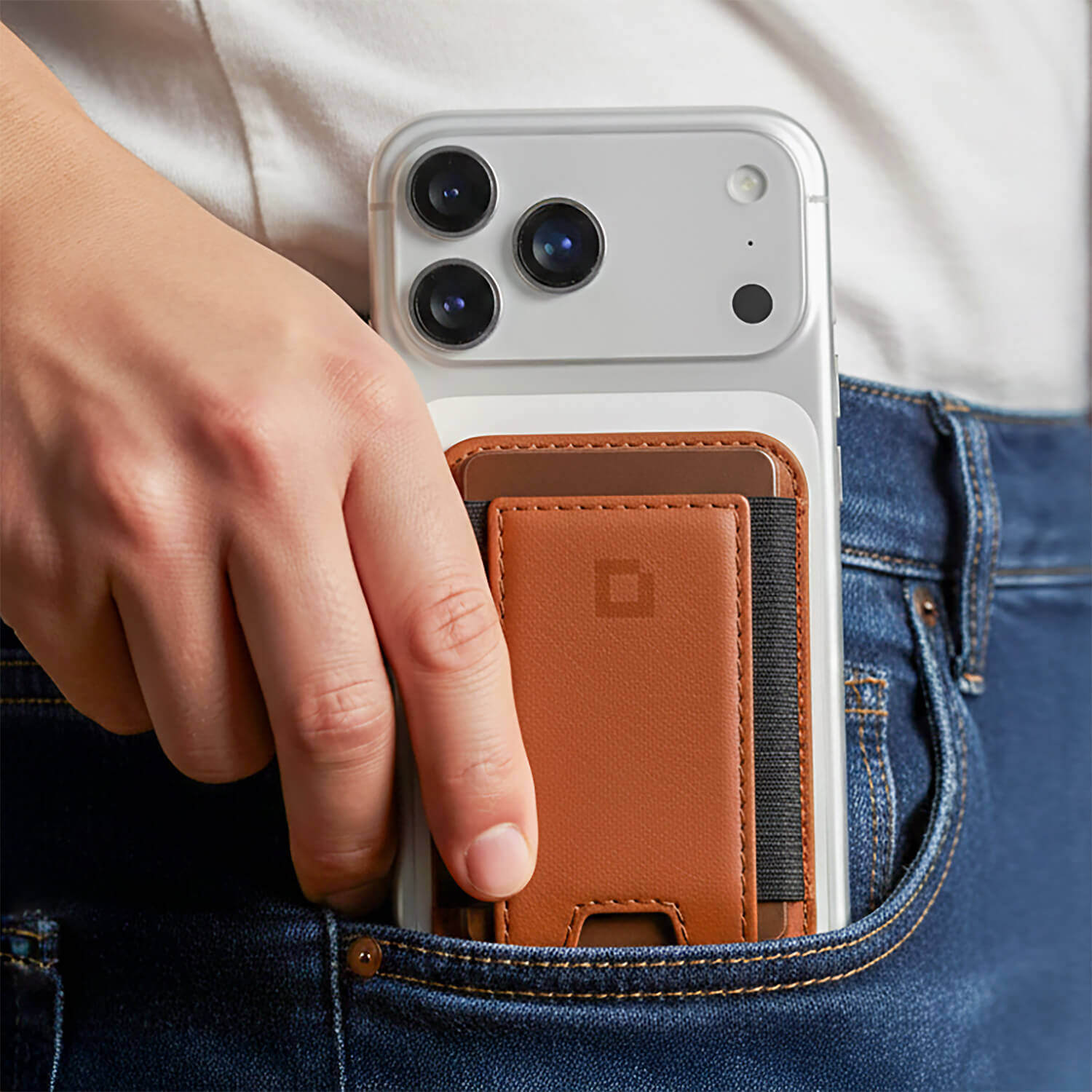 A MagSafe wallet with RFID blocking technology attached to the back of an iPhone.