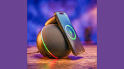 Handcrafted wireless-charging speaker with phone leaning on it, showing charging icon and colored ambient light.