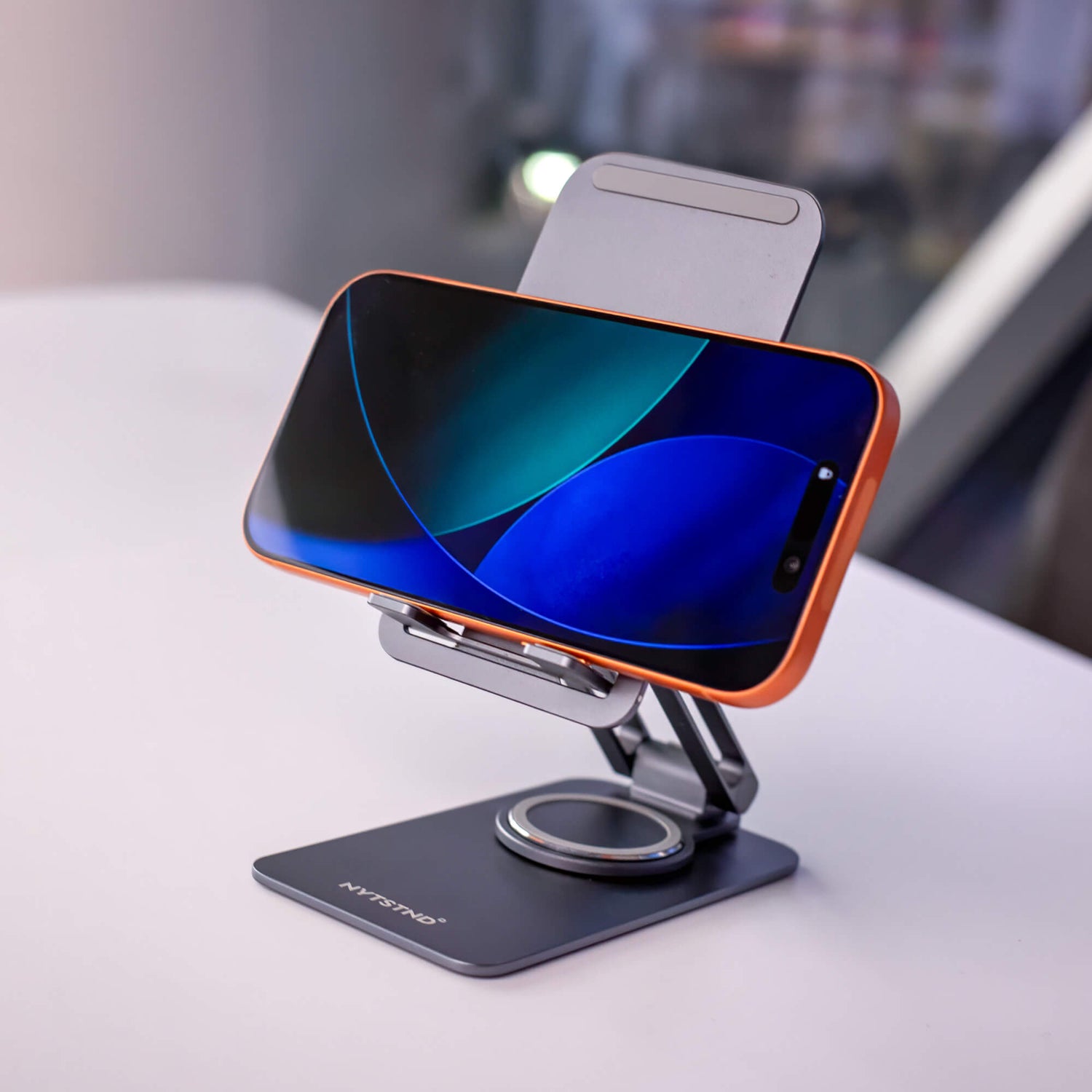 A charging station on a desk keeping a phone, watch, and laptop organized for a clean setup.