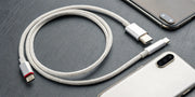 A braided USB-C to Lightning cable connected to an iPhone.
