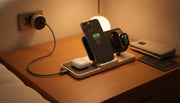 Premium travel charging station setup on a wooden nightstand with iPhone, AirPods, and Apple Watch