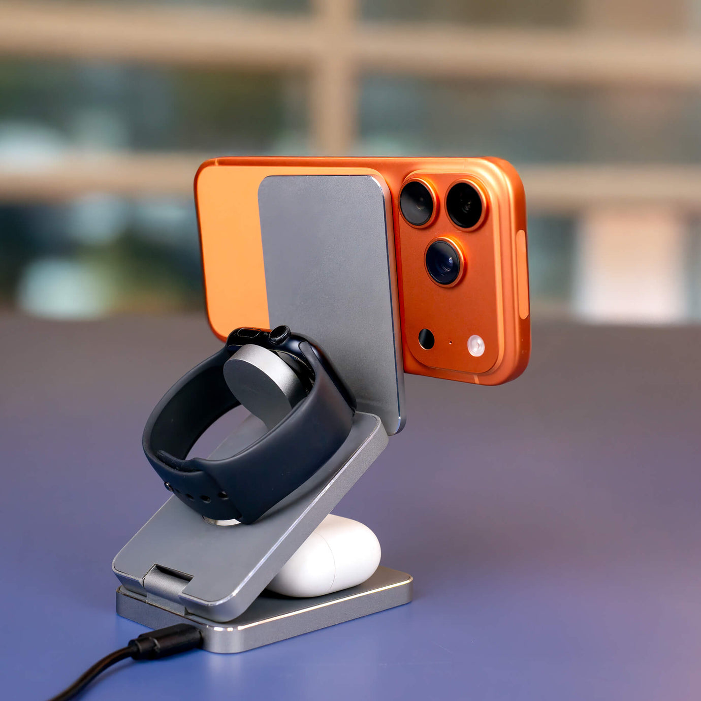 Foldable MagSafe travel charger and accessories on a hotel nightstand.