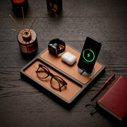 Premium home office desk with a wood wireless charging station featuring an iPhone, Apple Watch, and AirPods on a clean modern desk