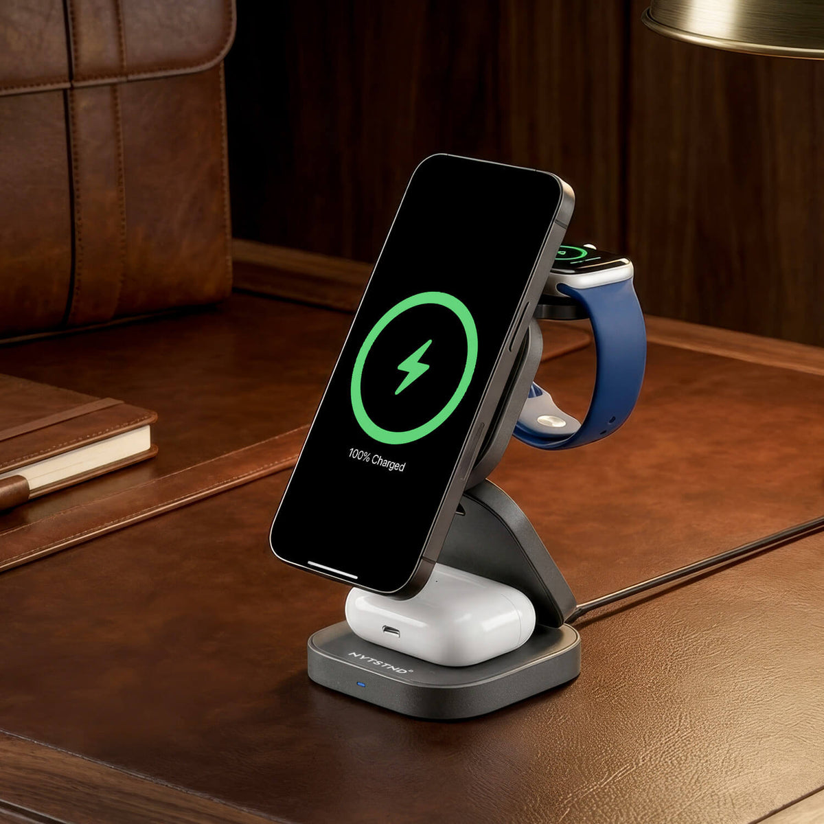 NYTSTND Trio Flex Qi2 Fast Wireless Charger — angled lifestyle shot shown charging devices