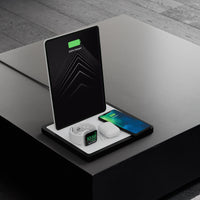 NYTSTND QUAD white leather top, midnight black wood base, lifestyle picture on the table angle view with devices 